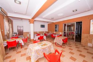 SpintexPemicsa Hotel Accra的用餐室配有桌子和红色椅子