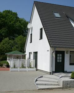 普特布斯Ferienwohnung Am Schlosspark的黑色屋顶的白色房子