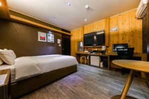 清州市Manhattan Hotel的酒店客房设有一张床、一张书桌和一台电视机。