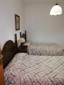 卡皮雷拉Apartamentos Cerro Negro - Los Magalites的一间卧室配有两张单人床和一盏灯。