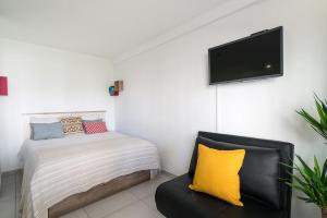 奎特里拉ImpervillaStudio - Vilamoura City Centre的一间卧室配有一张床、一张沙发和一台平面电视。