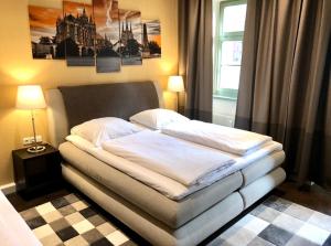 爱尔福特Markthof am Dom的卧室内的一张床位,配有两盏灯和一扇窗户