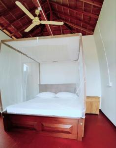 阿鲁甘湾Exotic Beach Hotel的配有吊扇的客房内的一张床位