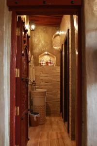 尼兹瓦Bait Al Aqr的走廊上设有带水槽和卫生间的浴室