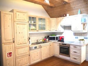 齐恩多夫CASA LOFT & LaMansarda的厨房配有木制橱柜和炉灶烤箱。