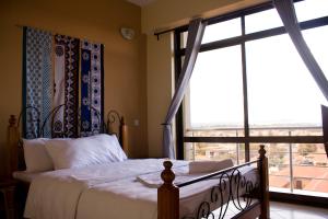 卡拉图Lilac Elevate Inn的一间卧室设有一张床和一个大窗户
