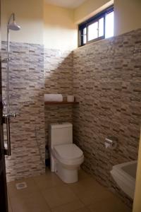 卡拉图Lilac Elevate Inn的一间带卫生间和砖墙的浴室