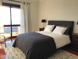 明德卢Beachfront Apartment with Swimming Pool的一间卧室设有一张大床和一个窗户。