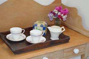淡水Stroud House的托盘,上面有两个茶杯和花瓶