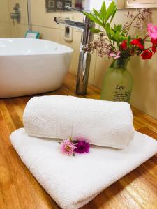 德尔迪阿布罗角Unique Hotel & Suites的浴室柜台上配有白色毛巾和水槽