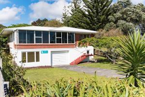 派西亚Te Ra Waitangi的一座白色的房子,在院子里设有车库