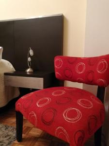 布宜诺斯艾利斯BairesTop con 2 dormitorios y estacionamiento的红色椅子,红色垫子座椅,旁边桌子