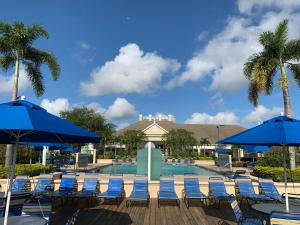 基西米威尼斯湾乡村度假酒店的一个带蓝色椅子和遮阳伞的游泳池