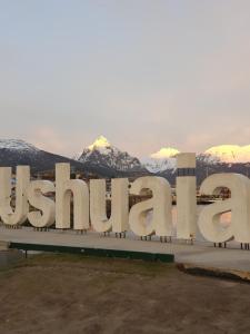 乌斯怀亚LiveUshuaia Beagle View Apartmento 2 dormitorios的底下有雪覆盖的山脉的大标志