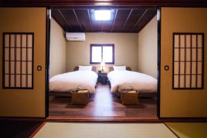 富山Kimachi-tei（きまち亭）的带两张床和镜子的客房