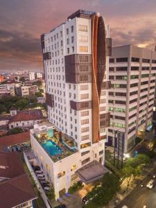 泗水CROWN PRINCE Hotel Surabaya Managed by Midtown Indonesia的一座白色的大建筑,前面设有一个游泳池