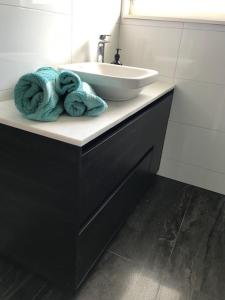 陶朗加TAURANGA, Bay of Plenty的浴室配有盥洗盆和带毛巾的台面。