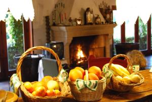 马尔科-德卡纳维泽斯Casa Dos Canais, River Cottage的桌上的三篮水果,壁炉