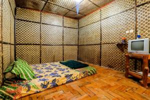 KalirejoLarasati Homestay的小房间设有床铺和电视