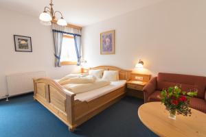 斯拉泽Aparthotel Ederhof的一间卧室配有一张床、一张沙发和一张桌子