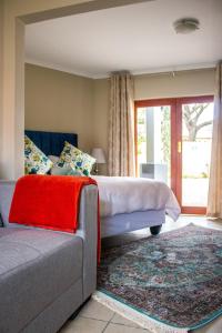 比勒陀利亚Pro Active Guest House的一间卧室配有一张床和一张沙发