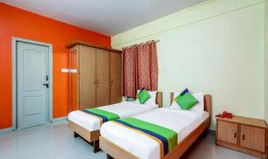 迈索尔Itsy By Treebo - Jasmine的橙色墙壁客房的两张床