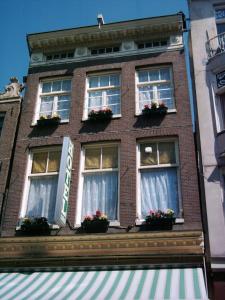 阿姆斯特丹施罗德酒店的一座高大的砖砌建筑,设有窗户和花箱
