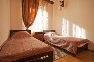 敖德萨乌宇提尼酒店的一间卧室设有两张床和窗户。
