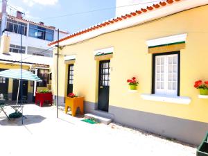 卡尔卡维洛斯茱莉亚帕蒂奥公寓的黄色的房子,设有窗户和雨伞