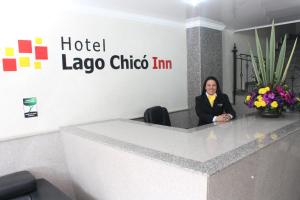 波哥大Hoteles Bogotá Inn Lago Chico的坐在酒店拉奥科巧克力公司桌子上的女人