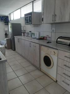 乔治Bergsight Self Catering Accommodation的厨房配有洗衣机和微波炉。