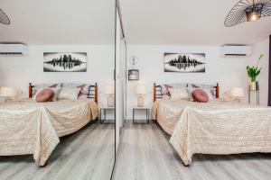 马卡尔斯卡诺拉公寓的一间卧室配有两张床和镜子