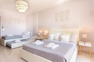 卡利亚里Residenze Su Planu的白色卧室配有两张床和一张沙发