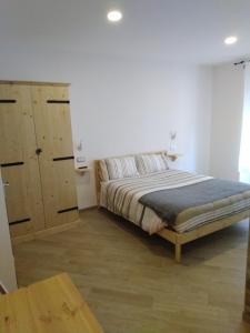 罗卡拉索Cristallo di neve b&b的一间卧室配有一张床和一个木制橱柜
