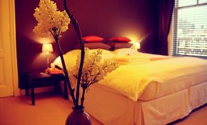 海牙印度支那庄园酒店的一间卧室配有床和花瓶