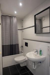 杜塞尔多夫阿图斯酒店的一间带水槽、卫生间和镜子的浴室