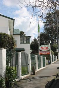 奥克兰格林兰庄园汽车旅馆的房屋前的白色围栏,上面有汽车旅馆标志