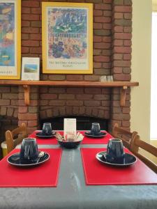 阿波罗湾安吉拉比奇住宿加早餐旅馆的一张桌子上装有红色餐巾和黑色帽子