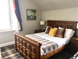 WhitebridgeWhitebridge Hotel的一间卧室配有一张带枕头的大型木制床。