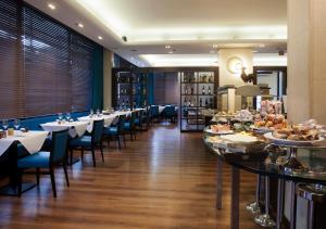 梅斯特LH Hotel Sirio Venice的一间带桌椅的餐厅以及一间自助餐
