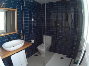 马萨龙港Sosiego Hostal de Mar的蓝色瓷砖浴室设有卫生间和淋浴。