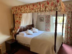 莫珀斯沃特福德住宿酒店的一间卧室设有天蓬床和窗户。
