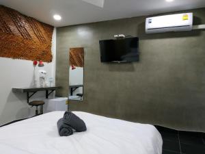 曼谷Hoft Hotel的卧室配有一张床铺,墙上配有电视