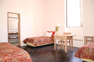 巴里查拉卡萨奥尼丽精品酒店的客房设有两张床、一张桌子和镜子