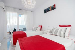 阿尔姆尼卡Casa Chana的白色卧室配有两张红色床单