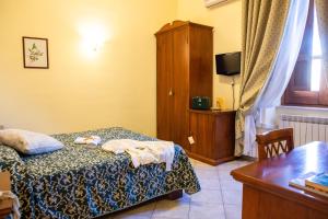 Arpino达皮诺伊尔骑士酒店的一间卧室配有一张床、一个橱柜和一张桌子