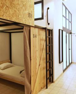 阿利坎特Hostel Numero Trece的客房设有带木门的双层床。