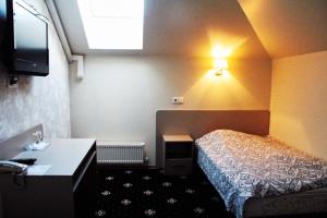 里加费利西亚酒店的小酒店客房配有一张床和一张书桌