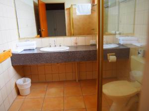 墨尔本埃森顿汽车旅馆的浴室设有2个水槽、卫生间和镜子。