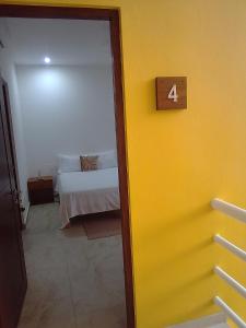 图卢姆posada tumben ka´a的一间设有床和黄色墙壁的客房